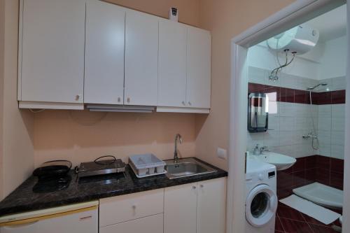 萨兰达Noel Sea View Apartments的一个带水槽和洗衣机的小厨房