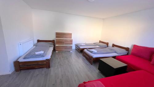 塞内奇Apartmánový dom Most pri Bratislave的带三张床和红色沙发的房间