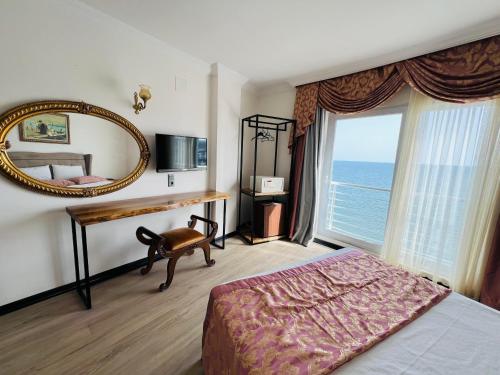 ErdemliRoxo Beach Hotel的一间卧室配有一张床、镜子和窗户