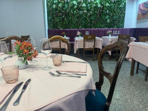 VergatoDa Noi Trattoria Hotel的用餐室配有桌椅和白色的桌布