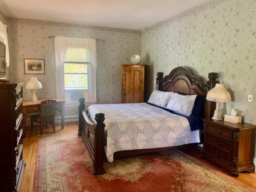 弗雷德里克顿卡瑞奇豪斯旅馆的一间卧室配有一张床、一张桌子和一个窗户。