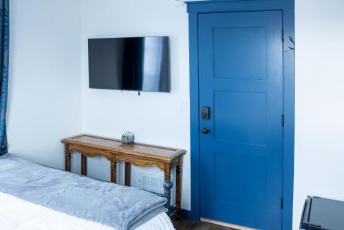 帕尔默Van Wormer Room 201, Hyland Hotel的一间卧室设有蓝色的门和一张桌子