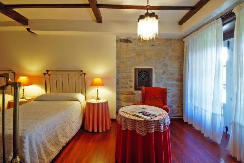 阿波夫拉德特里韦斯Casa Grande De Trives的卧室配有1张床、1张桌子和1把椅子