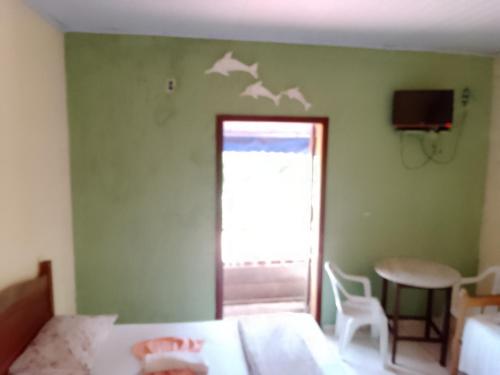 帕拉蒂Canto do mar的一间卧室设有一张床,墙上有窗户,有鸟儿