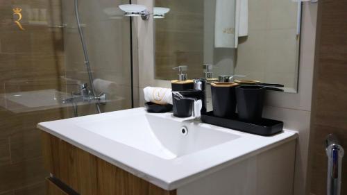 阿布扎比Glen 2BR Duplex Masdar city的浴室配有白色水槽和淋浴。