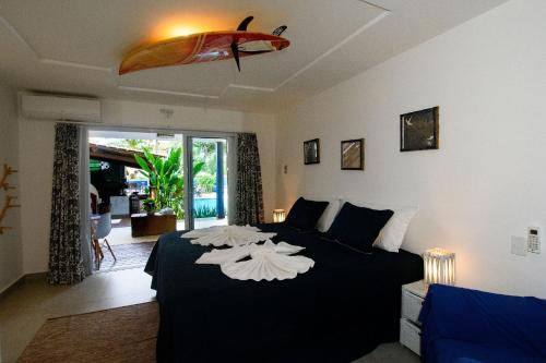 阿拉亚尔达茹达Aqui Bate a Brisa Pousada的一间卧室配有一张带冲浪板的床