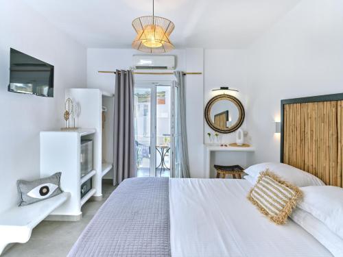 纳乌萨梅思娜独家公寓式酒店的白色卧室配有床和镜子