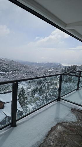 圣卡洛斯-德巴里洛切Monoambiente a estrenar en Bariloche的窗户享有雪覆盖的山谷美景。