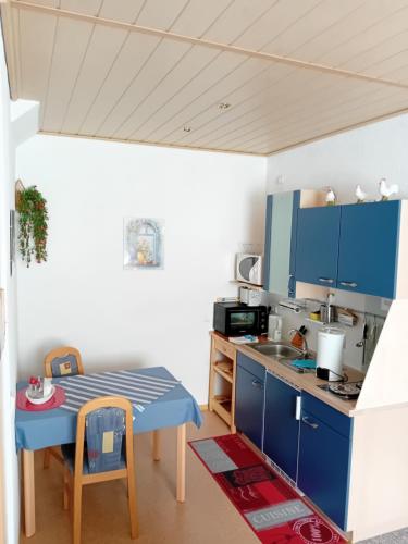 奥伯霍夫豪斯希泽布格公寓的厨房配有蓝色橱柜和桌子