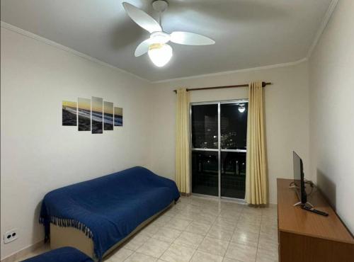 蒙加瓜Apartamento pé na areia de frente para o mar的一间卧室设有蓝色的床和窗户。