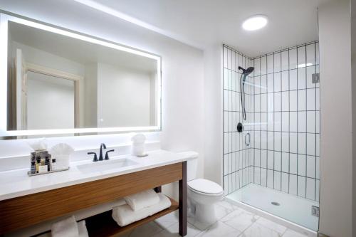 威奇托老城区酒店的白色的浴室设有水槽和淋浴。