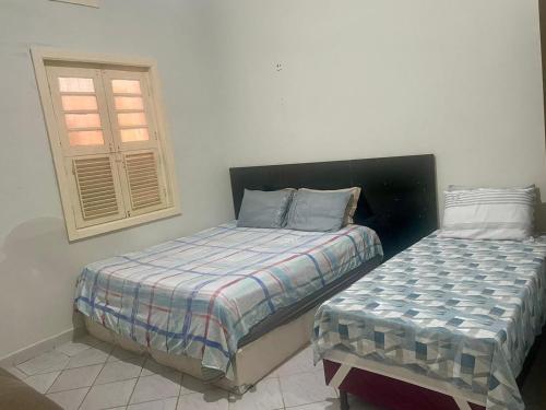 贝伦Casa Maria Toda Linda的一间卧室设有两张床和窗户。