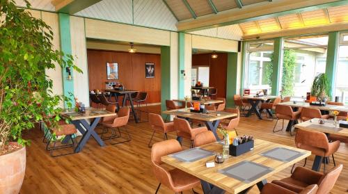 布兰肯堡Harz Hotel Vogelberg的一间在房间内配有桌椅的餐厅