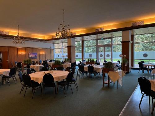 布兰肯堡Harz Hotel Vogelberg的用餐室设有桌椅和窗户。