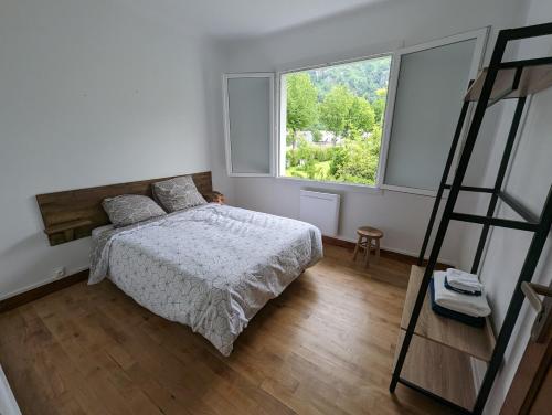 拉兰Maison rénovée sur Laruns的一间卧室设有一张床和一个大窗户