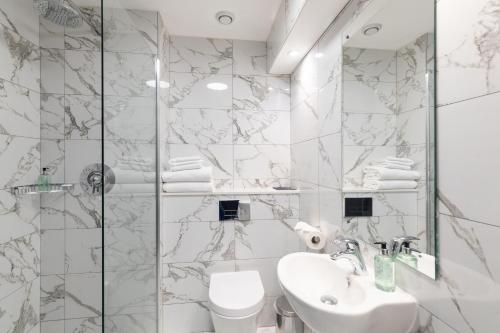 利物浦托马斯爵士酒店的白色的浴室设有水槽和淋浴。