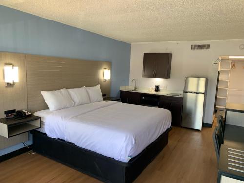 科迪尔Suburban Studios的酒店客房设有一张大床和一个厨房。