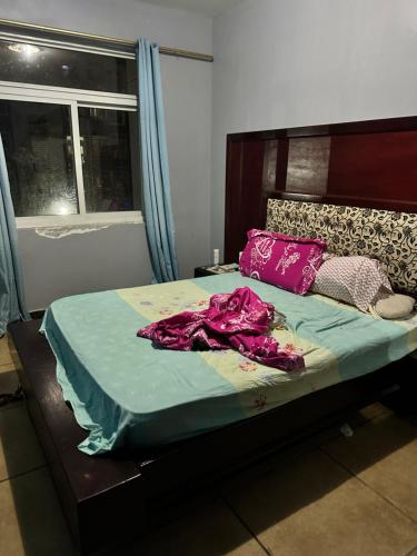 丘达德马拉波Maqueda 2. Sanjo的一间卧室配有一张带紫色床单的床和窗户。