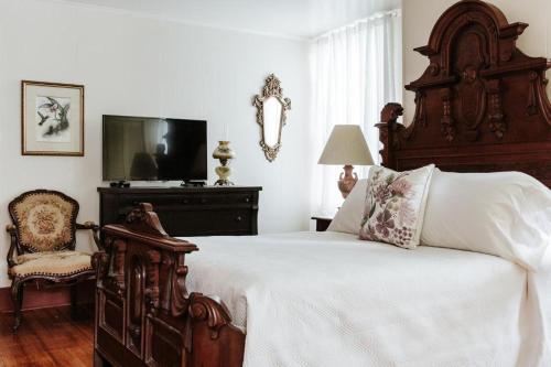 拉斐特Maison Mouton Bed & Breakfast的一间卧室配有一张大床和一把椅子