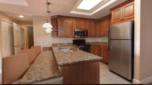 奥兰多Westgate Town Center Resorts的厨房配有木制橱柜和不锈钢冰箱。