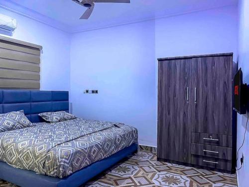 塔马拉Adnan lodge的一间卧室配有蓝色的床和木制橱柜