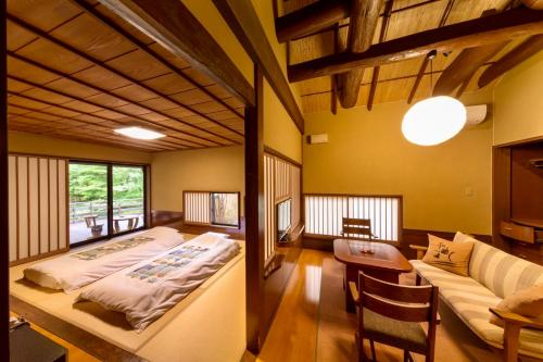 南小国町Satonoyu Waraku 13 years or older的一间卧室配有一张床和一个沙发