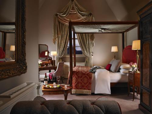 纳斯吉拉塞酒店的一间卧室设有一张大天蓬床和一张桌子