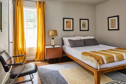 伯明翰Modern, Pet-Friendly Retreat, Named Best BnB in Bham的卧室配有床、椅子和窗户。