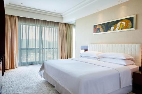 杭州杭州龙禧福朋喜来登酒店的卧室设有白色的床和大窗户