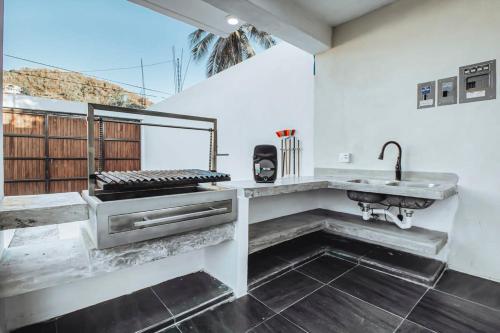 拉曼萨尼亚Beautiful getaway near the beach的厨房设有白色的墙壁、水槽和柜台。
