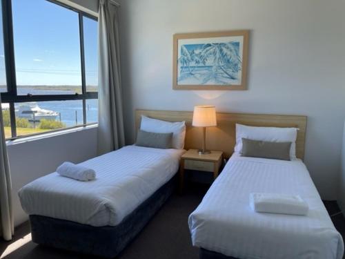 茶园船屋豪华公寓的配有窗户的酒店客房内的两张床