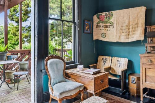 旧金山Historic & Charming Victorian Home Sleeps 11的客房设有桌子、椅子和窗户。