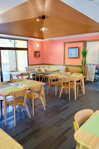 雾岛市Auberge Arigatou的用餐室配有木桌和椅子