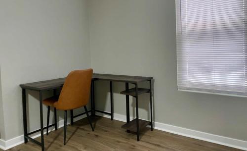 奥马哈Cozy Aksarben Living-close to I-80 & WFH desk的一张桌子和一张橙色椅子