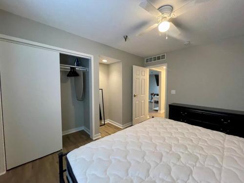 奥马哈Cozy Aksarben Living-close to I-80 & WFH desk的卧室配有白色的床和吊扇