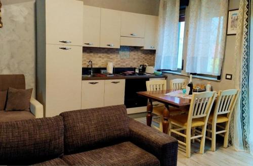 扎费拉纳-埃特内阿Etna apartments的带沙发和桌子的客厅以及厨房。