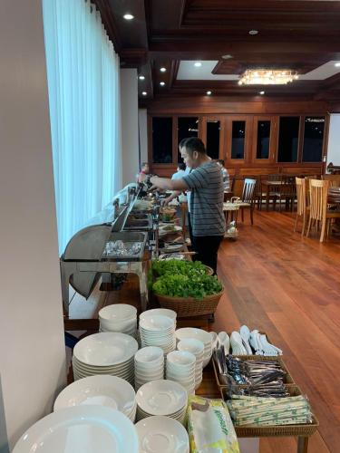 沙湾拿吉HotelLaoMixay的站在桌子上,拿着盘子和碗的人