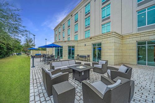 查尔斯顿Holiday Inn Express & Suites Charleston Arpt-Conv Ctr Area, an IHG Hotel的大楼前带桌椅的天井