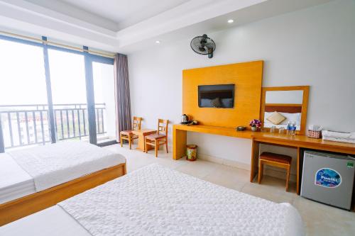 岑山UFJ HOTEL Sầm Sơn的一间卧室配有两张床和一张带镜子的书桌