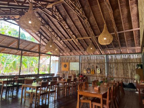 布纳肯3WILL Bunaken Dive Resort的餐厅设有木桌和椅子及灯