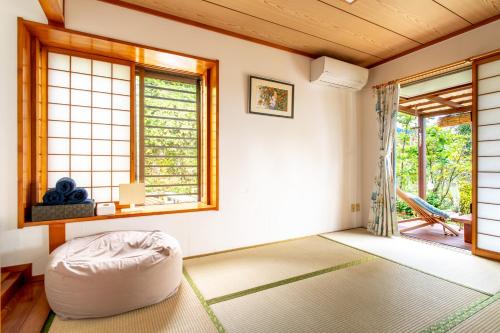 读谷村Beach House Yomitan的一个带奥斯曼式凳子的客厅,位于带窗户的房间里