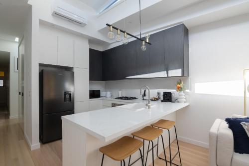 悉尼Unionelle a Luxe Newtown Terrance的厨房配有白色台面和黑色橱柜