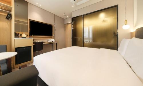 釜山Busan Myeongji Ciel Ocean Hotel的酒店客房设有一张白色大床和一张书桌