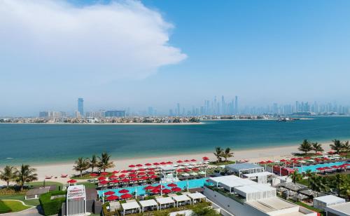 迪拜Th8 Palm Dubai Beach Resort Vignette Collection, an IHG hotel的海滩空中美景,配有遮阳伞