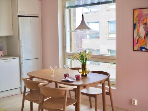 赫尔辛基Candy-Colored Two-Room Condo with Sweet views的厨房配有桌椅和窗户。