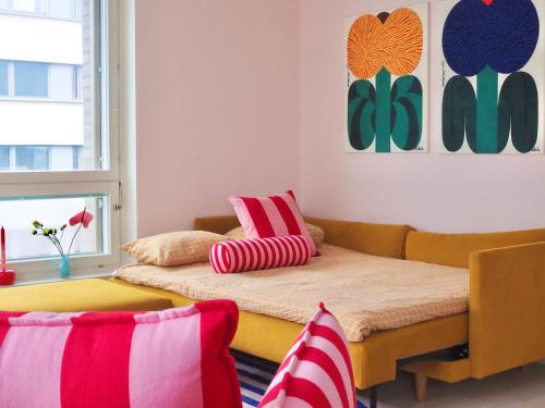 赫尔辛基Candy-Colored Two-Room Condo with Sweet views的客房设有一张沙发和一张带枕头的床。