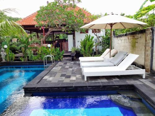 蓝梦岛Villa Cempaka Lembongan的一个带遮阳伞和椅子的庭院和一个游泳池