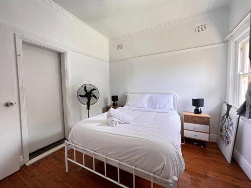 悉尼Budget 1 bedroom unit near Maroubra Beach的白色的卧室设有白色的床和窗户。