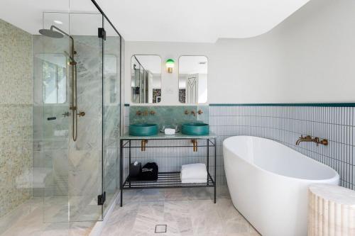 悉尼202 Elizabeth Hotel - The Oxford - Australia的带浴缸和玻璃淋浴间的浴室。
