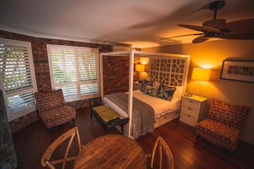 巴利纳波丽娜棕榈精品汽车旅馆的卧室配有一张床和一张桌子及椅子